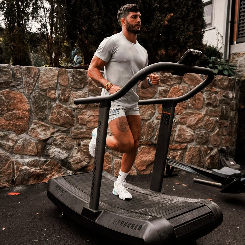 Sportler läuft auf einem AssaultRunner Laufband im Freien.