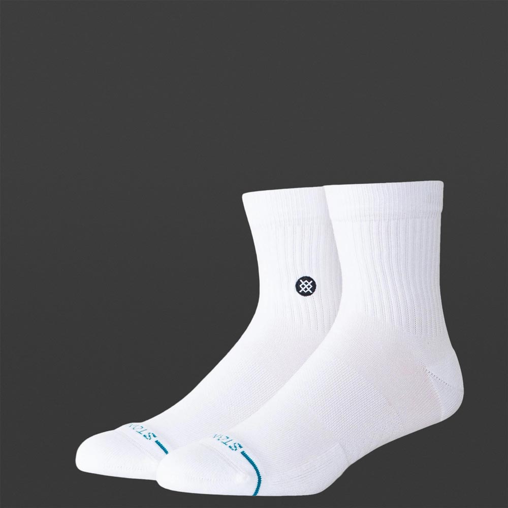 Zwei weiße Stance Icon Quarter Socken auf dunklem Hintergrund, leicht seitlich angeordnet. Sichtbares Stance-Logo an der Außenseite und blaue Linie an der Zehenpartie.