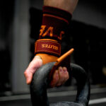Training mit Kettlebell und orangenen Velites Handschuhen