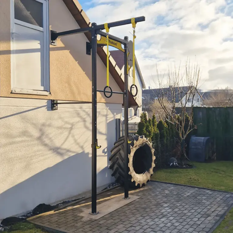 Affenhand Wandrig mit Turnringen an einer Hauswand im Außenbereich.