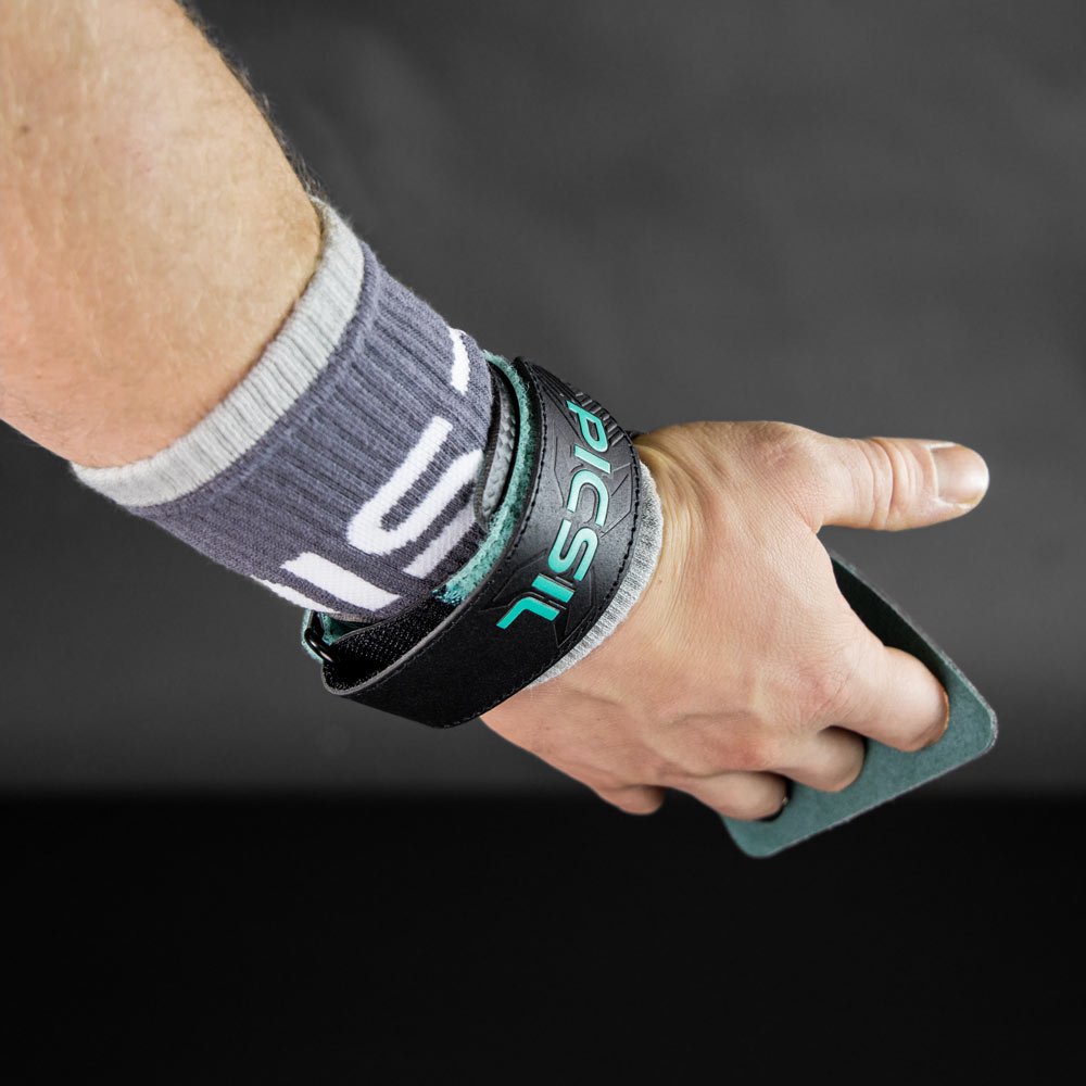 Picsil Wrist Band mit Handschutz liegt neben einer Kettlebell.