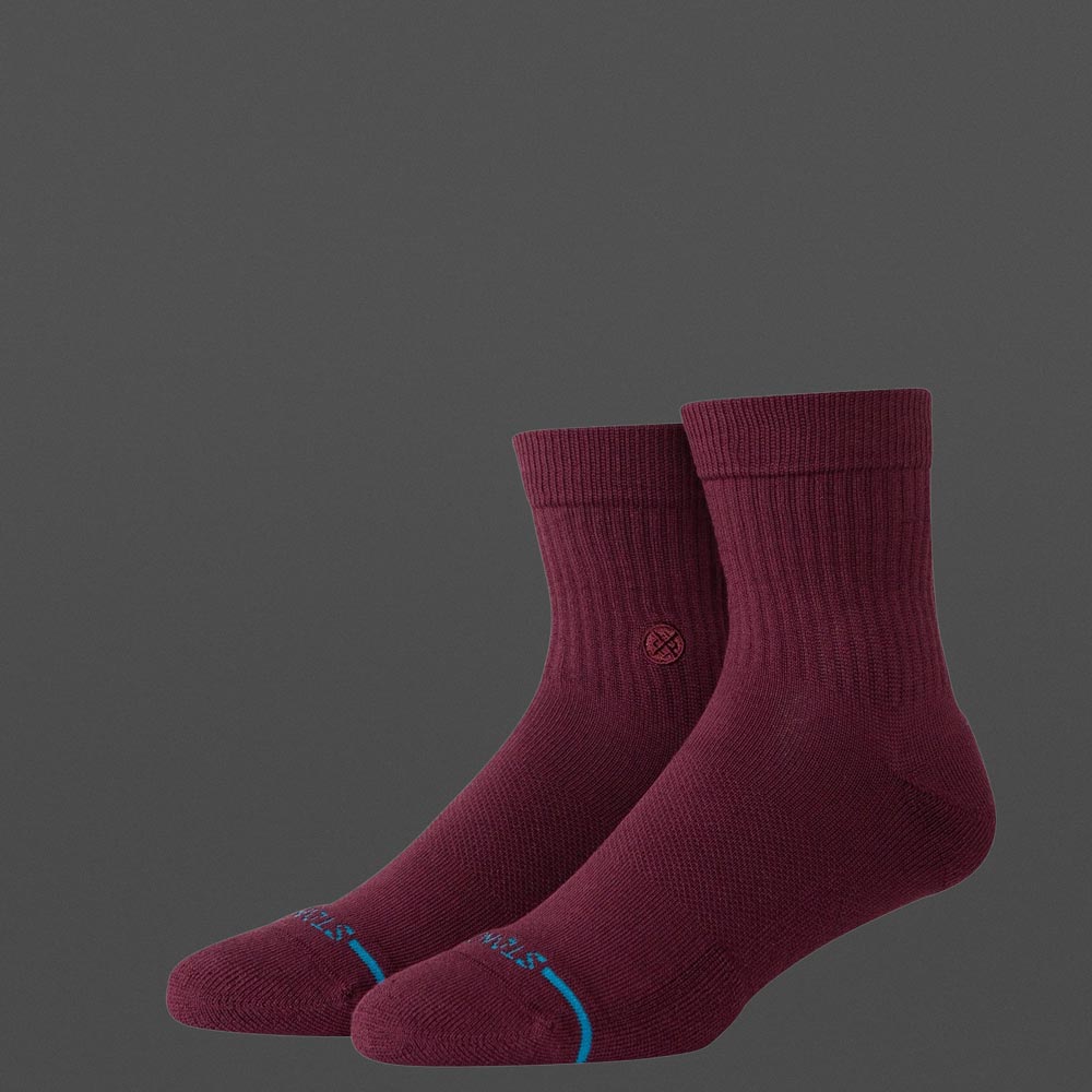 Zwei Stance Icon Quarter Socken in Weinrot auf grauem Hintergrund, seitlich fotografiert mit sichtbarem Stance-Logo und blauer Linie an der Zehenkante.