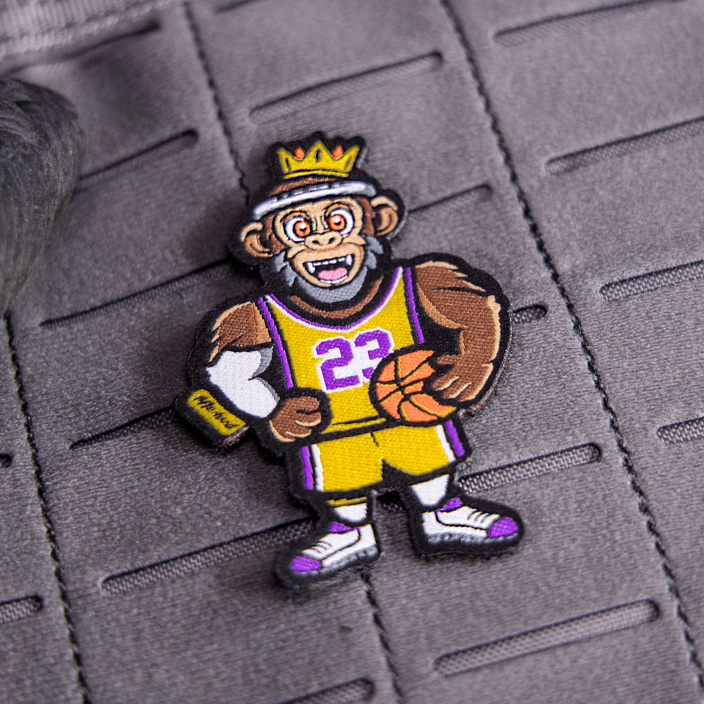 LeBoss King Klett-Patch, befestigt auf einer grauen Klettfläche, zeigt den Gorilla mit einem Basketball.