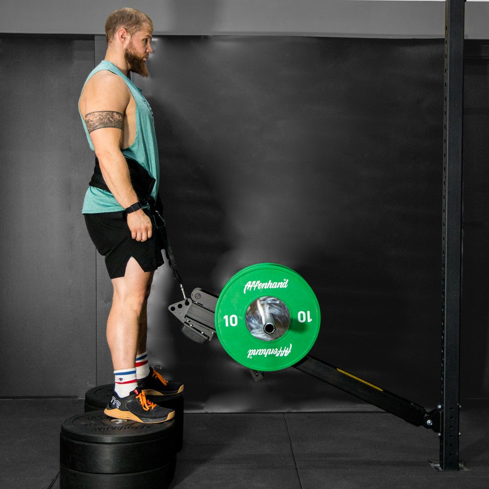 Sportler bei der Nutzung der Affenhand Belt Squat Erweiterung, effektives Beintraining.
